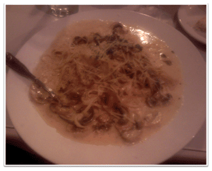 Picture of Scallops with a cream reduction sauce mushrooms and capers over linguini 