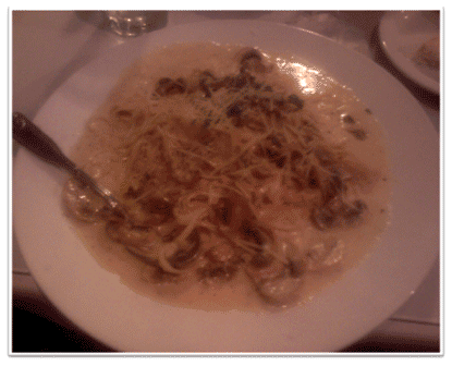 Picture of Scallops with a cream reduction sauce mushrooms and capers over linguini